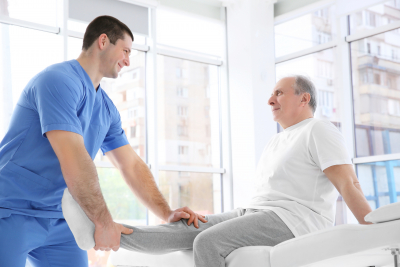 Physiotherapist working with elderly patient in clinic