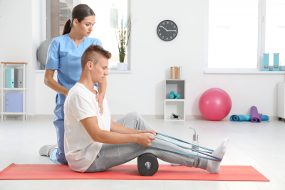 Physiotherapist working with young male patient in clinic